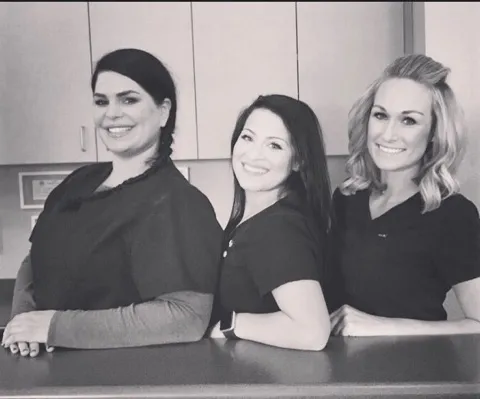 3 staff members standing in front of the desk